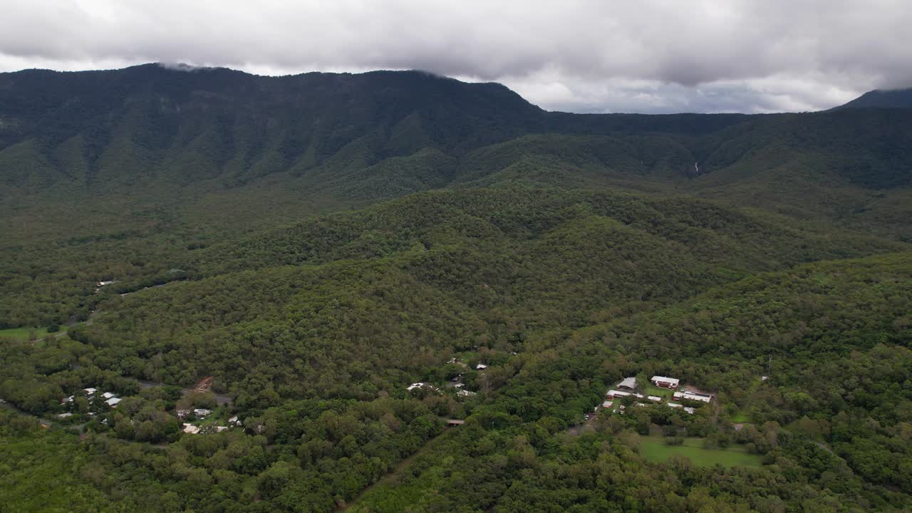 vista aérea de la selva tropical, las colinas y las casas en la costa este de australia, paisaje panorámico en un día nublado