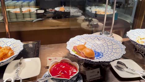 a buffet dish is replenished with fresh food in a well-lit restaurant environment, showcasing a dynamic dining experience