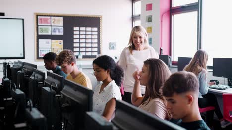 female teacher helping teenage girl high school student working in computer class