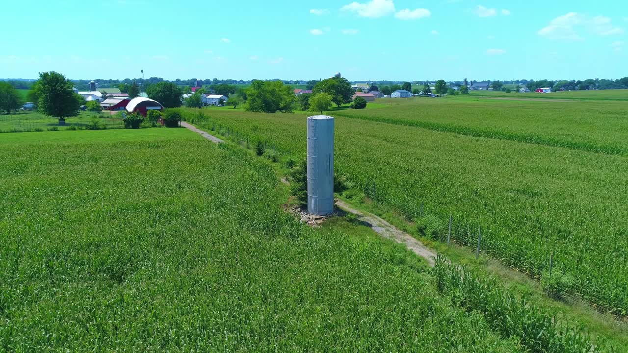 вид с воздуха на старую водонапорную башню посреди зеленого кукурузного поля