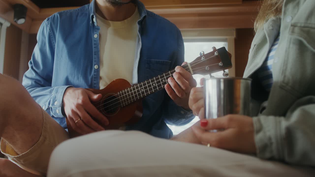 una pareja tocando el ukulele en una caravana.