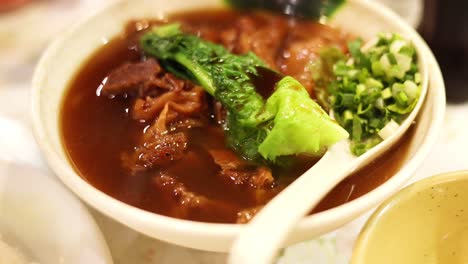 delicious noodle bowl with meat and greens