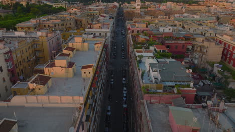 Hochwinkelansicht-Der-Straße-Zwischen-Mehrstöckigen-Wohnhäusern-Mit-Dachterrassen.-Stürmer-Fliegen-In-Der-Abenddämmerung-über-Dem-Stadtteil.-Rom,-Italien