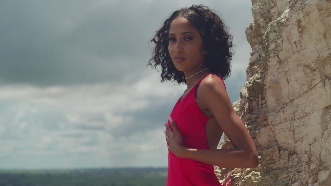 Beautiful Woman in Red Dress Posing on a Cliff