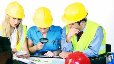 arquitectos que trabajan con planos en la oficina