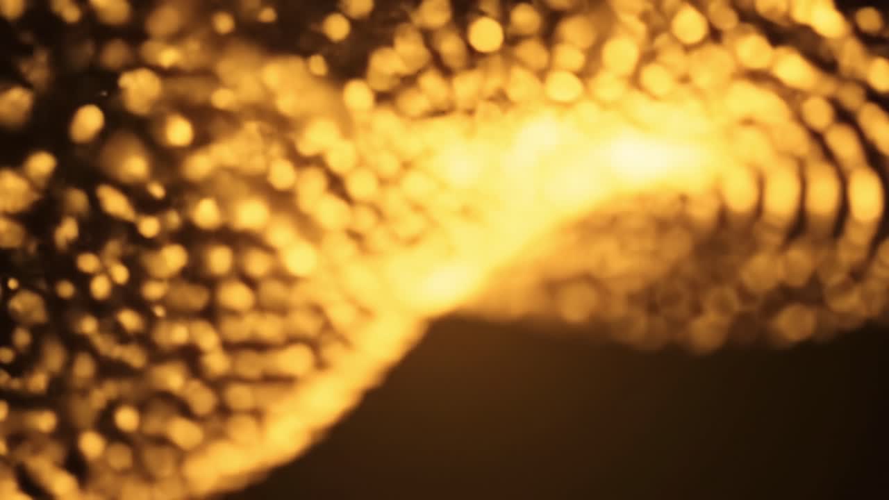 A mesmerizing water fountain illuminated with golden light creates a beautiful atmosphere at dusk in a vibrant city park. Visitors admire the artistic water movement.