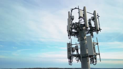 disparo aéreo girando alrededor de la torre de teléfono celular con el cielo azul en el fondo