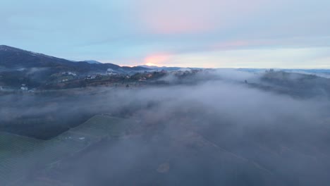 fog over countryside landscape in italy with dawning sky on horizon