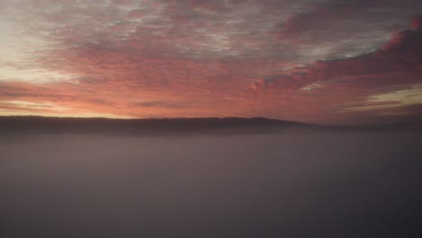 a natural spectacle: red and orange sunset over fog mist