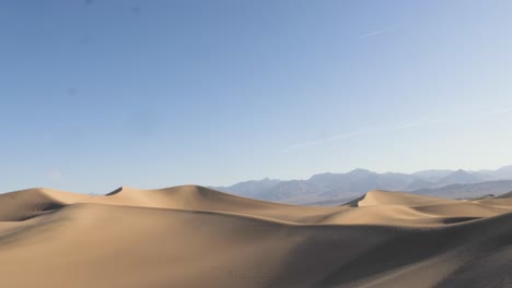 Inclinación-En-Cámara-Lenta-Desde-Las-Dunas-De-Arena-Planas-De-Mezquite-Hasta-El-Cielo-Azul-Claro-En-El-Parque-Nacional-Del-Valle-De-La-Muerte