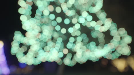 twinkling blurry cyan and white christmas lights with circular bokeh on tree