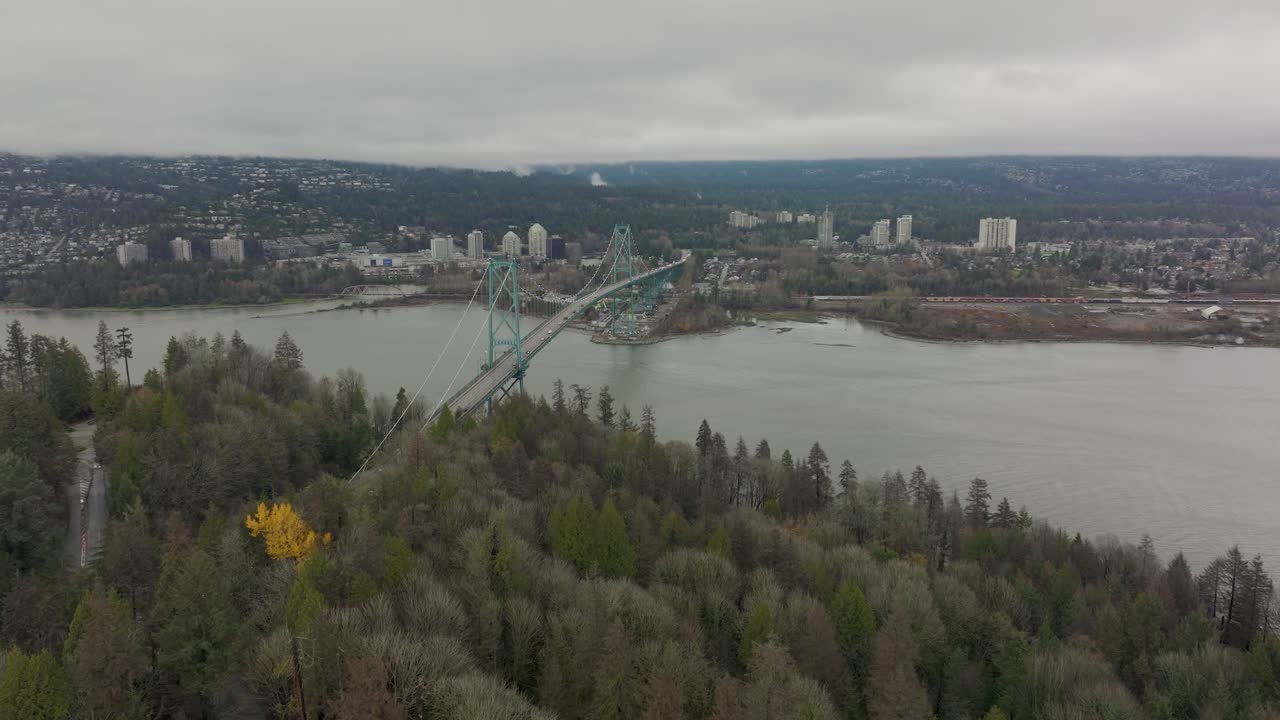 toma aérea de drones volando hacia el paisaje urbano del norte de vancouver pasando el puente de la puerta de los leones en 4k