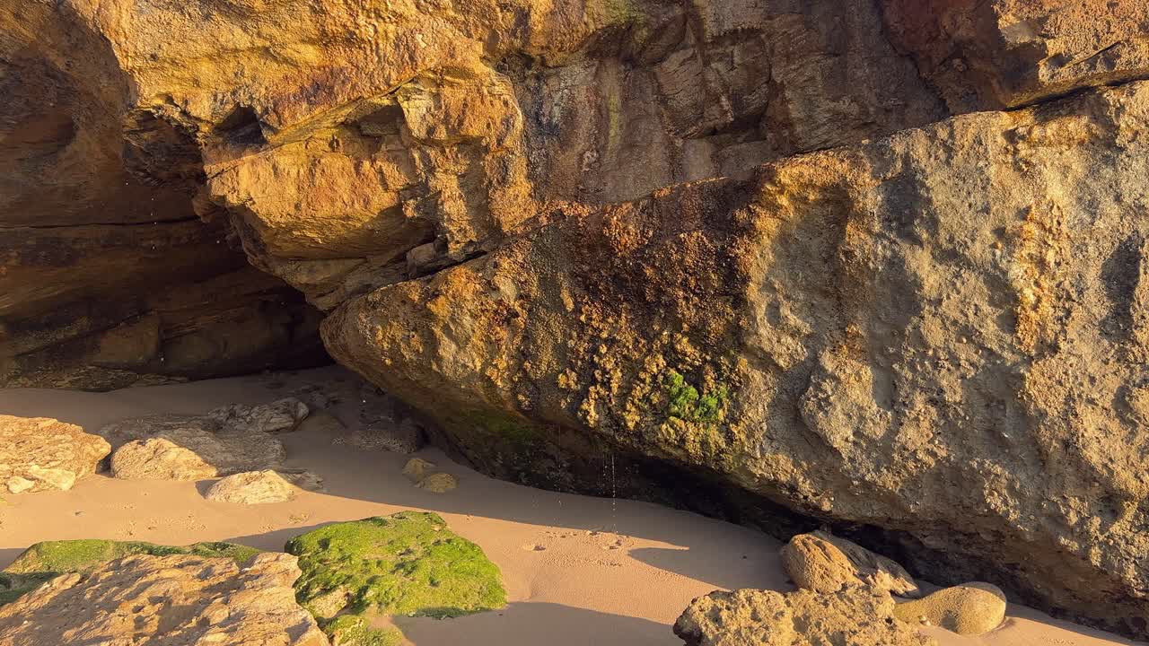 Droppande stenar nära stranden vid soluppgången, dagtid