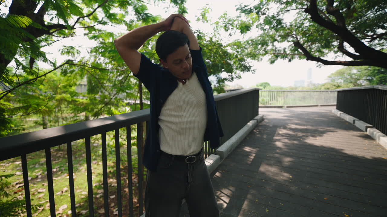 Man stretching on a bridge