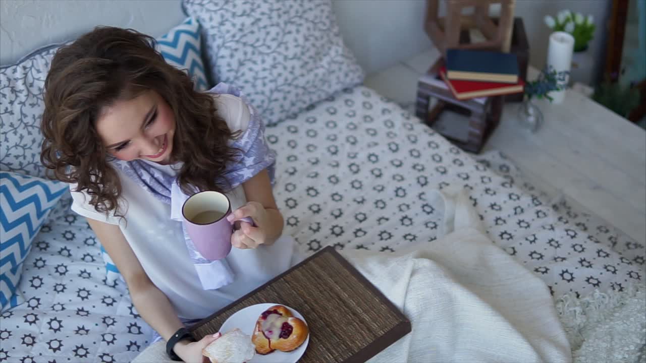 mujer disfrutando del desayuno en la cama