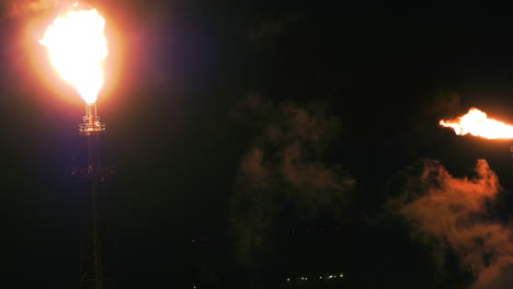 flaring oil refinery pipes, at a industrial process plant, nighttime in usa