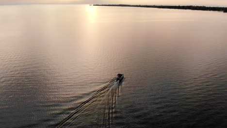 drone footage of recreational boat cruising on lake huron during sunset in michigan