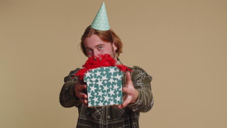 smiling man presenting birthday gift box stretches out hands, offer wrapped present career bonus