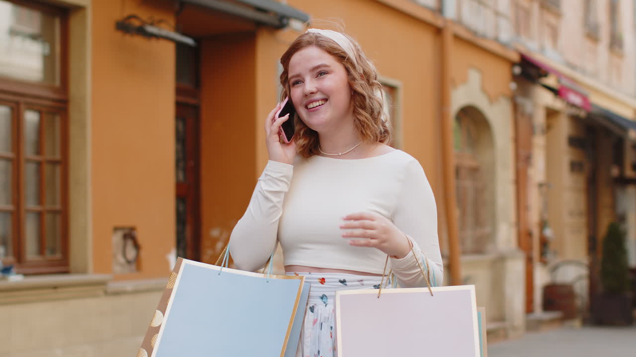 mujer feliz adicta a las compras consumidor después de la venta de compras con bolsas llenas de regalos hablando en el teléfono inteligente