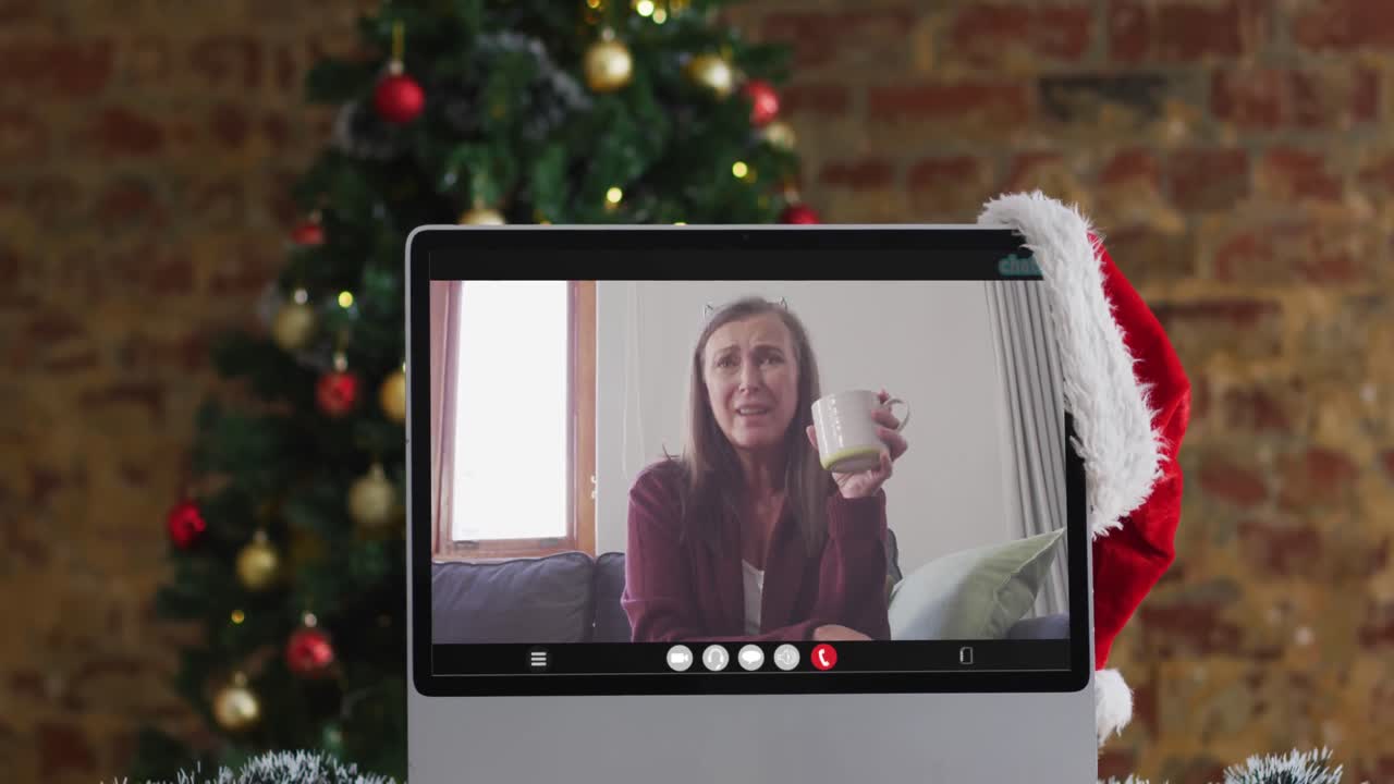 Anziana donna caucasica felice in videochiamata al computer, con decorazioni e albero di Natale