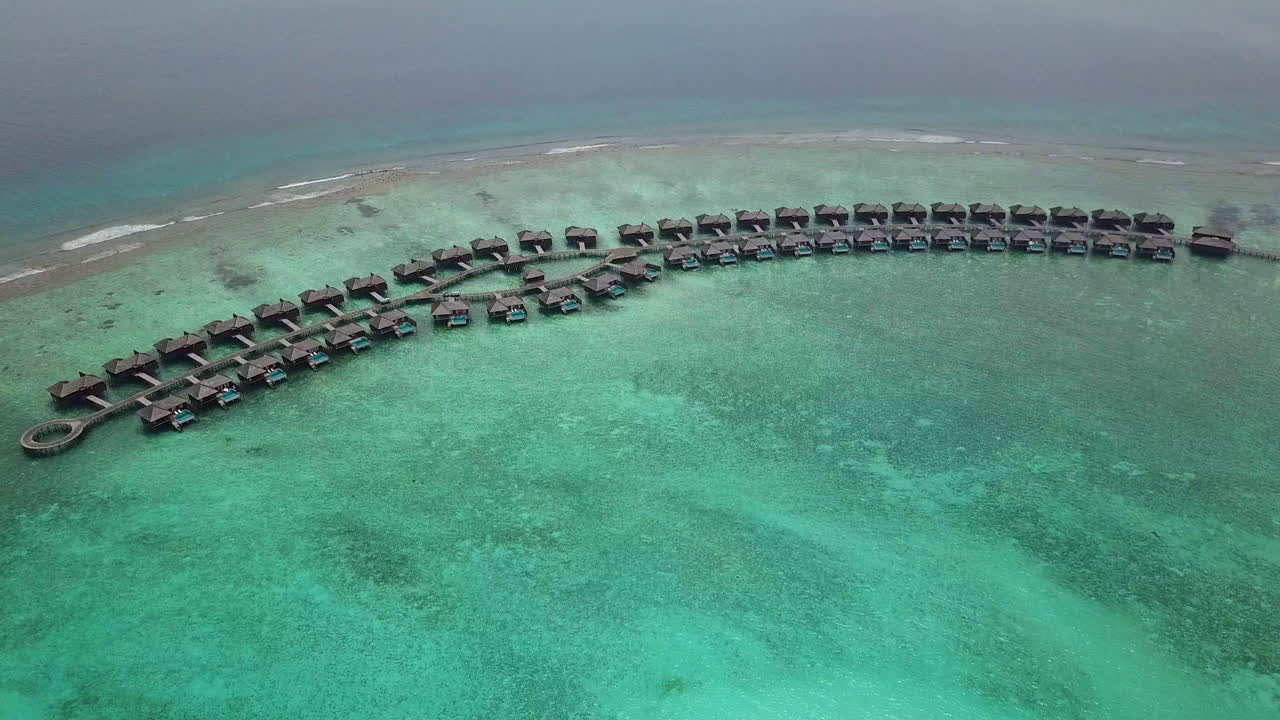 Ampia ripresa con drone inclinata verso il basso di ville private sull'acqua turchese