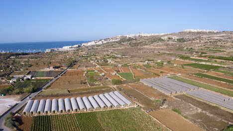 zona agrícola con campos, cultivos y silos cerca de la ciudad costera, malta