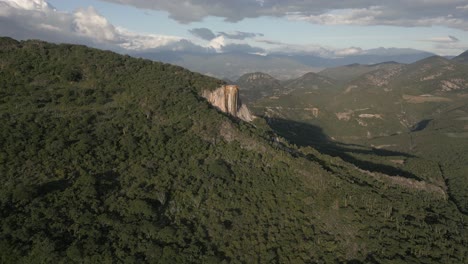 aerial orbits tall calcite flowstone rock cliff at hierve el agua, mx