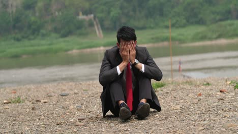 depressed businessman by the river