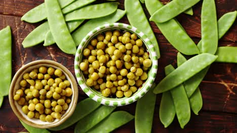 Green-pea-in-ceramic-bowls-placed-on-wooden-background