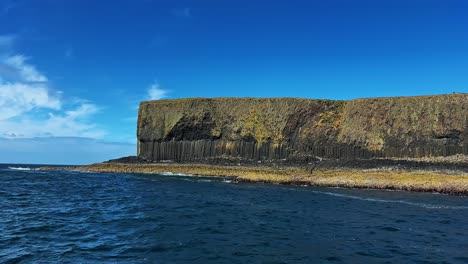 staffa island with columnar basalt by the blue sea seen from the boat in scotland. - wide shot