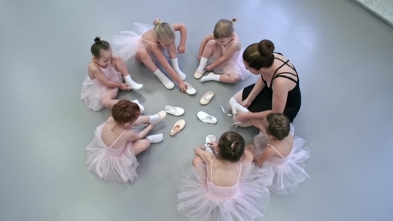 Seduti in cerchio durante una lezione di balletto.