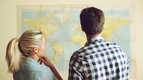 young tourist couple looking at world map