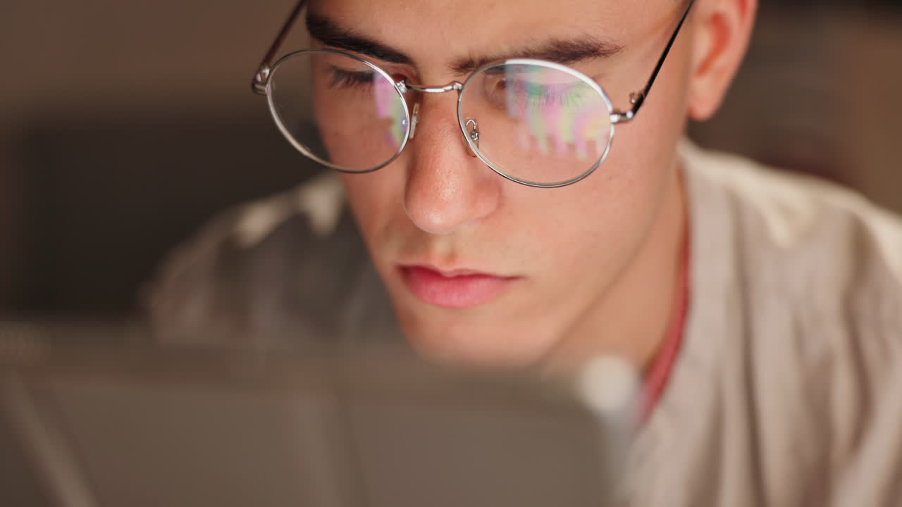 Man with glasses looking at screen