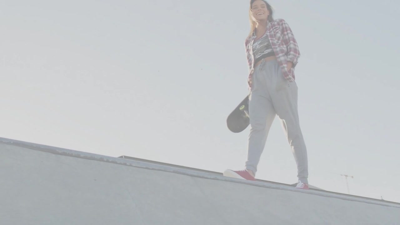Una skater donna cammina lungo un bordo di cemento, creando linee animate che mostrano l'allenamento per sport da tavola.