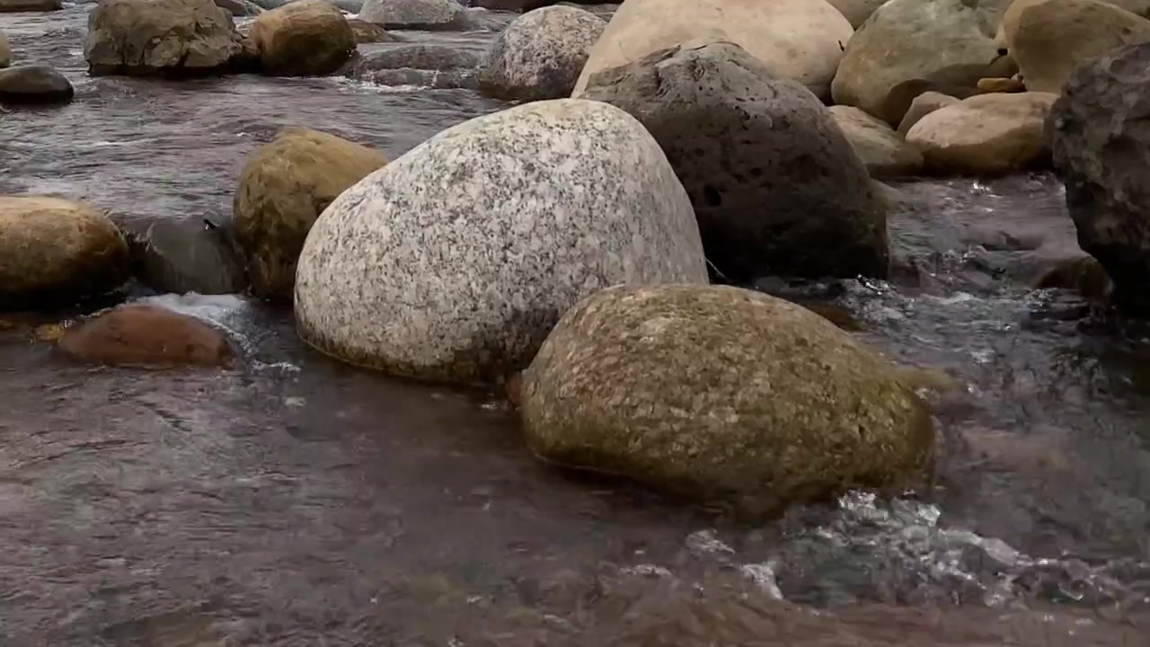 Massi lisci e arrotondati che riposano in un fiume poco profondo che scorre in Bangladesh