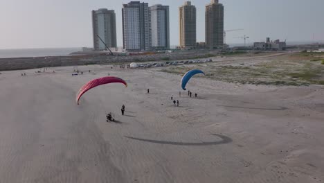 Aeril-shot-of-a-number-of-acro-paraglider-in-the-beach-of-Karachi,-Pakistan