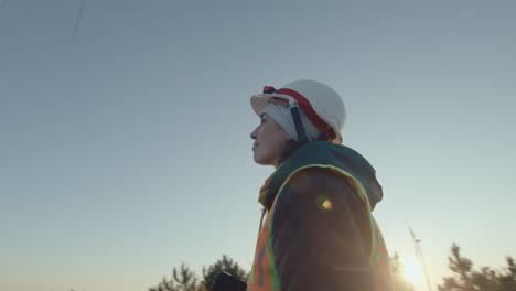 female renewable energy engineer walking at wind farm