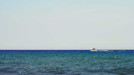 Deck-boat-passing-by-on-a-clear-day-with-strong-winds