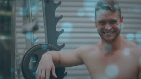 animación de manchas brillantes sobre un hombre fuerte haciendo ejercicio en el gimnasio