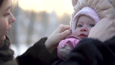 mother dressing baby in winter