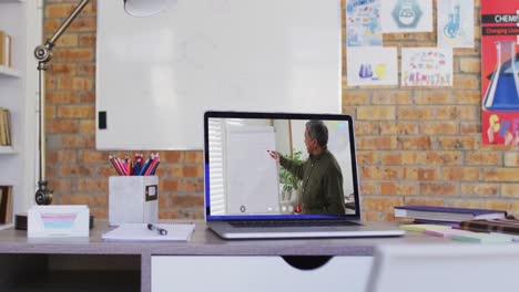 Mixed-race-male-teacher-on-laptop-screen-during-video-call