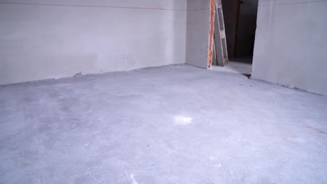 empty unfinished room with concrete floor and electrical installations during renovation