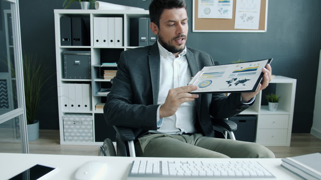 Businessman in Wheelchair Reviewing Documents in Office