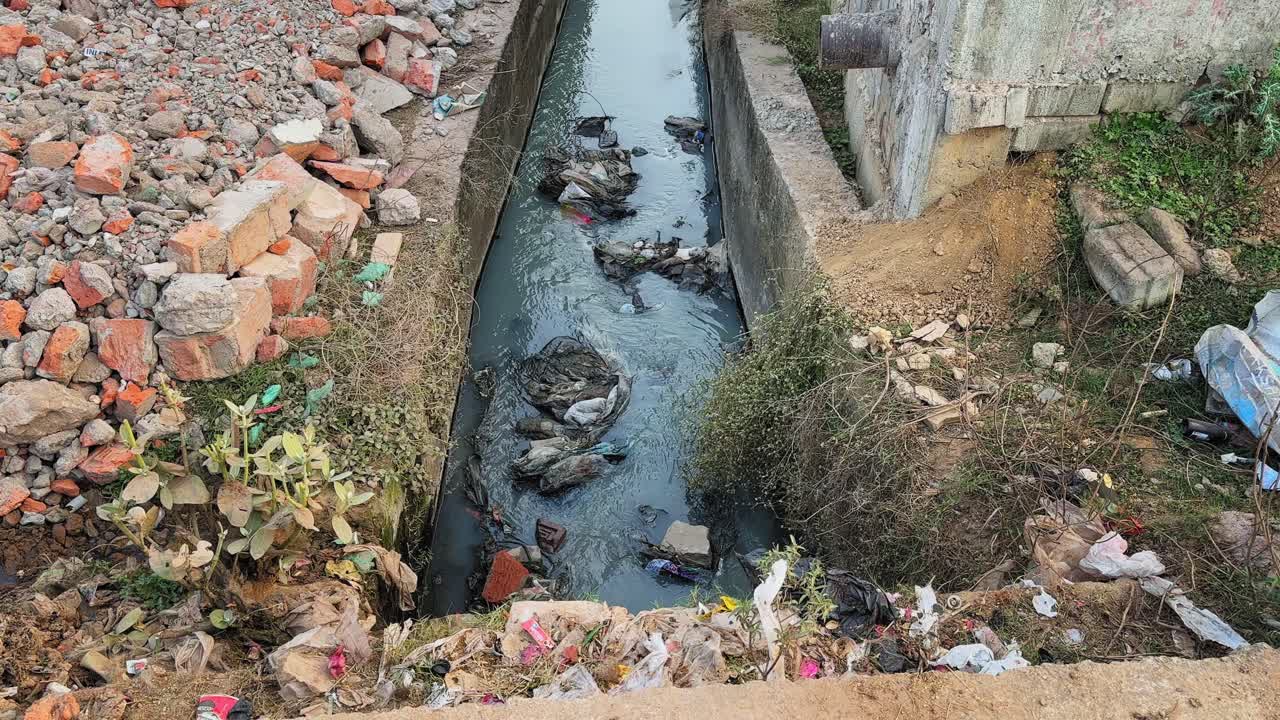Saluran drainase beton terbuka yang mengalirkan air tercemar dengan ...