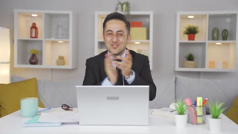 home office worker man looking at camera clapping and getting excited.