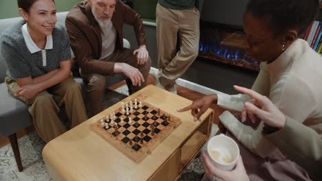 diverse group of friends playing chess in a cozy living room