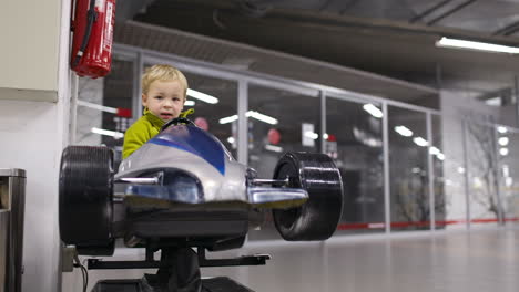 little boy driving a racing car