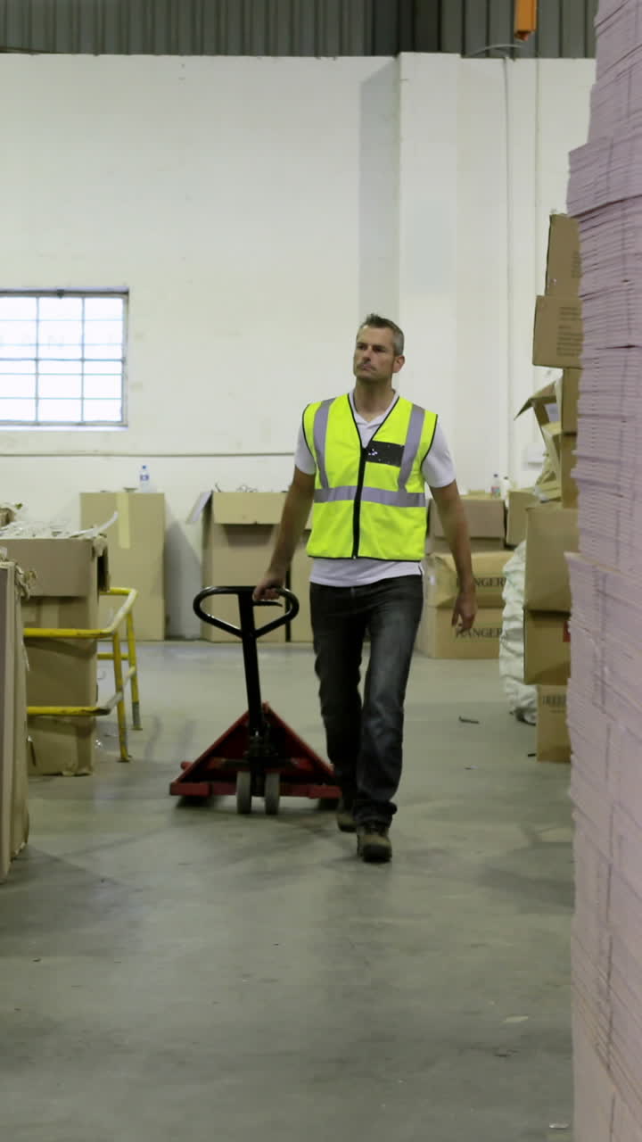 trabajador de almacén tirando del carrito a la cámara