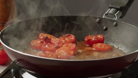 cooking sliced tomatoes in a pan