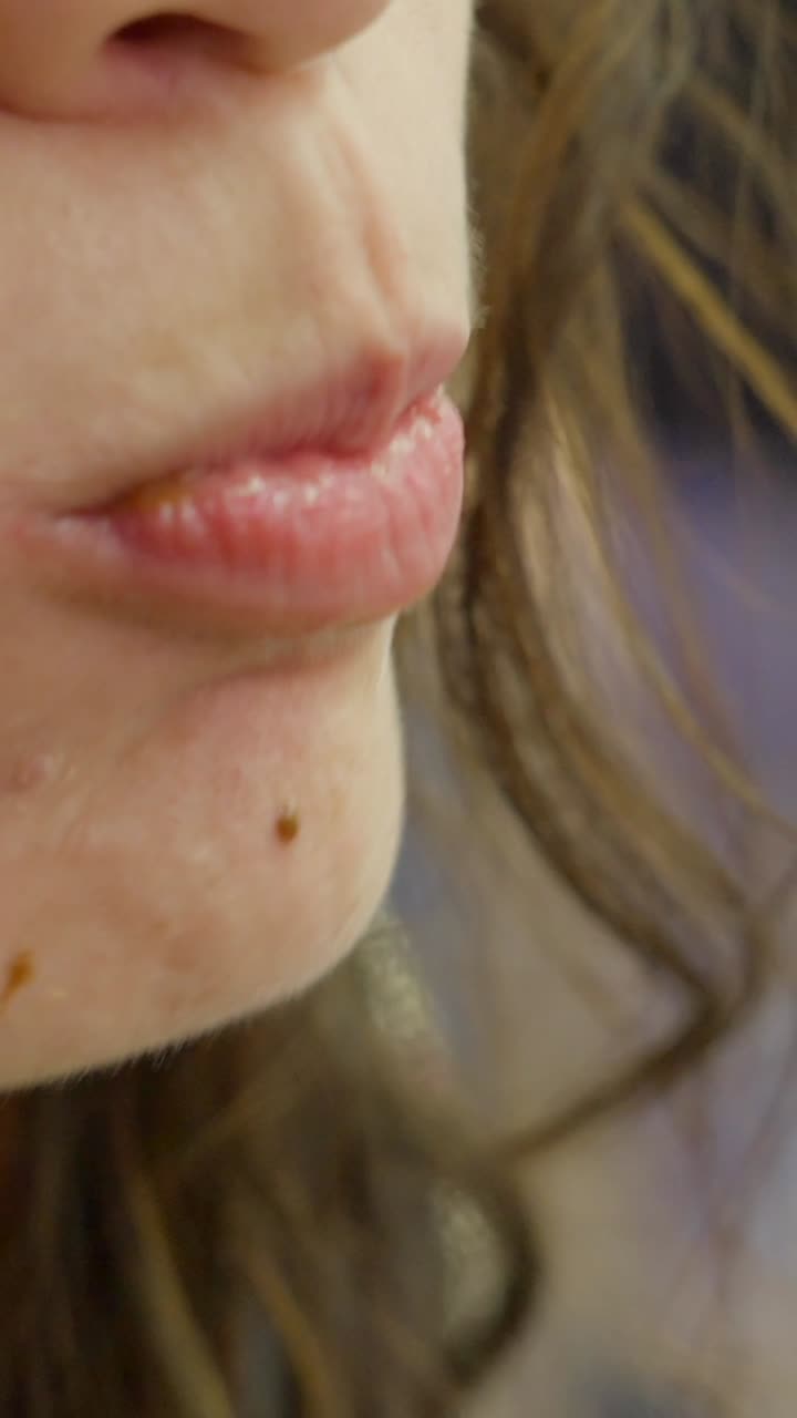 A close-up view of a person eating a delicious waffle with chocolate or caramel sauce